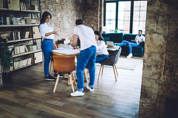 Concentrated colleagues working on drafts in spacious loft workspace