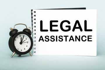 A words LEGAL ASSISTANCE on notebook with clock. Concept for time management and business.
