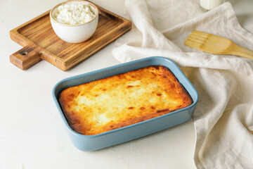 Dish with tasty cottage cheese casserole on light background