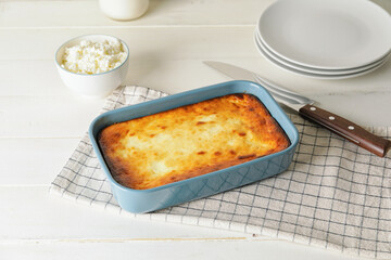 Dish with tasty cottage cheese casserole on white wooden background