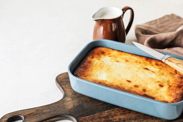 Dish with tasty cottage cheese casserole on light background