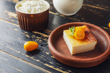 Plate with piece of cottage cheese casserole on wooden background