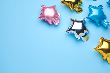 Balloons in shape of stars on color background