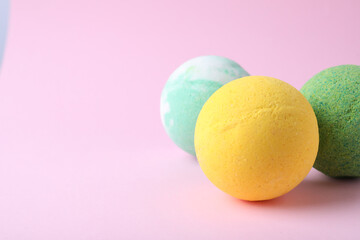 Colorful bath bombs on pink background, closeup. Space for text