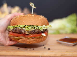 big burger in a cafe on a wooden table