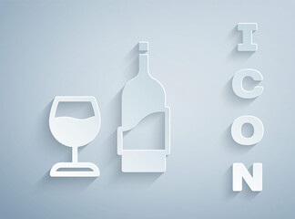 Paper cut Wine bottle with glass icon isolated on grey background. Paper art style. Vector