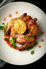 Grilled quail with lemon and sauce on a plate - 433821718