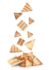 Delicious crispy pita chips falling into heap on white background