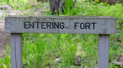 A close view of the old wood entering sign.
