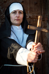 Young energetic, arraged nun shows cross