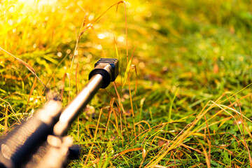 Aiming a rifle in the autumn grass covered with morning dew and sunlit. Close up view from ground...