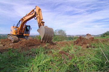 Pelle mécanique,  pelleteuse effectuant des travaux de terrassement en vu de la construction d'un lotissement © sablin