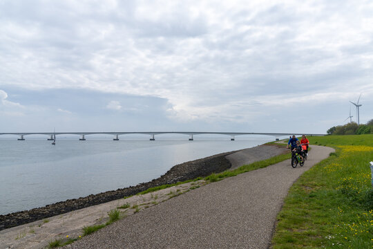 family enjoying ab bicycle ride along the Eastern Scheidt Estuary with the Zeelandbrug the background