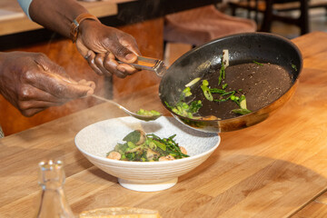 A delicious plate of potatoes fricassee with tiger prawns and green peas