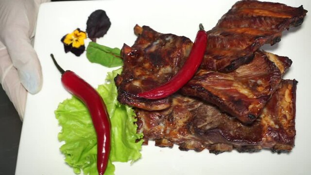 Cook shows off fried ribs with red chili peppers