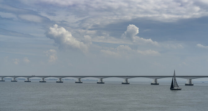 sailboat on a turn in the Eastern Scheidt Estuary with the Zeeland Bridge in the background