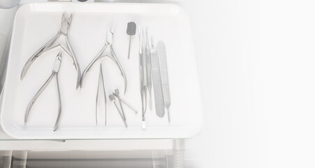 Medical instruments on a white tray with white copy space at the right. Chiropody tools. Nail...