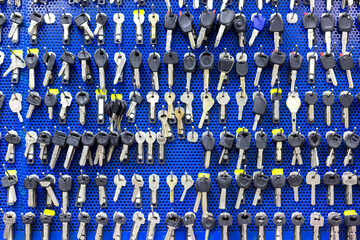 Many keys hang on the wall as a background, texture, pattern. Workshop for making keys.