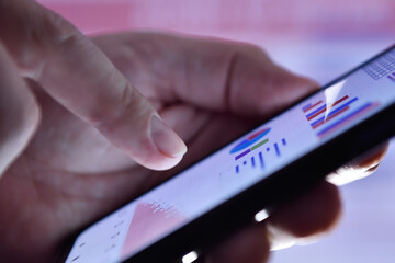 Trader man hands checks business report on cellphone.