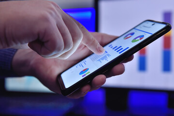Businessman hands using smart phone and analyzes business report.