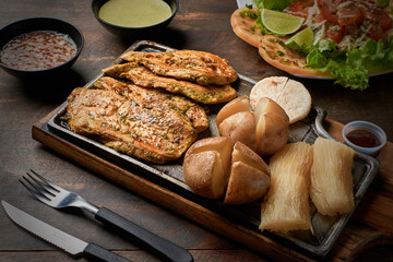 Grilled chicken fillet accompanied by salad and sauce