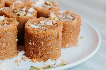 Close up of Wheat laddu - Roasted wheat flour mixed with Desi Ghee and sugar to make tasty and sweet Laddu. Served in a dish on table