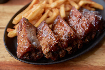 Smoked ribs ready to be eaten on wooden plate.​

