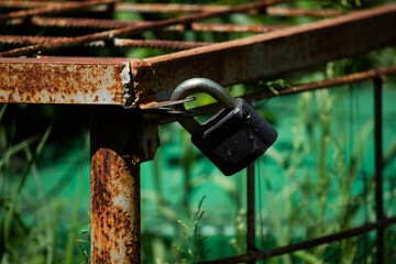 Old rusty padlock hanging on metal 
