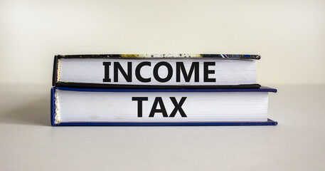 Income tax symbol. Concept words 'income tax' on books on a beautiful white background. Business, income tax concept.
