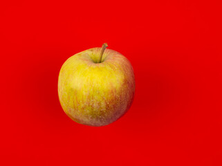 Fresh red apple on red background.