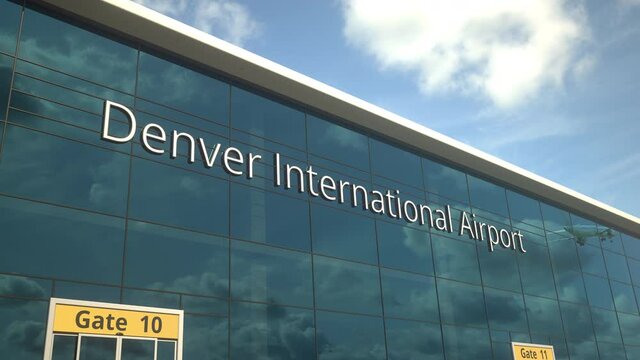Taking off airplane reflecting in the modern windows with Denver International Airport text