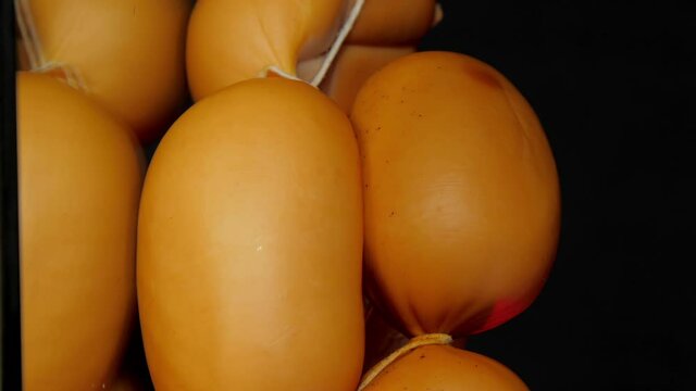 Tasty raw bangers bunch of brown colour lie on black kitchen table reflecting bright light vertical super close view