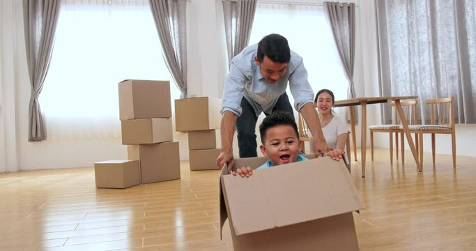 Family Is Having Fun With Cardboard Boxes In New House
