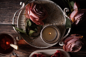 Sicht von Oben, Auf dem Tisch steht Himbeere Torte, Glas Tee,  ein Metalltablett mit Rosen, Kerzenständer, Drei Rosen im Alt Rose', , Frauen Hände sind zu sehen