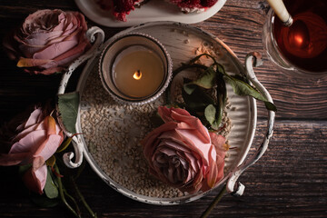 Sicht von Oben, Auf dem Tisch steht Himbeere Torte, Glas Tee,  ein Metalltablett mit Rosen, Kerzenständer, Drei Rosen im Alt Rose', , Frauen Hände sind zu sehen