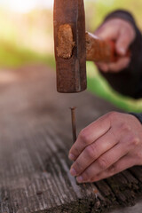 Close-up of hammering a nail into the board. 