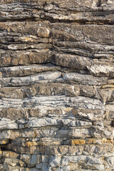 Beautiful natural stone background, layered texture of a mountain cliff. Dinaric Alps, Montenegro