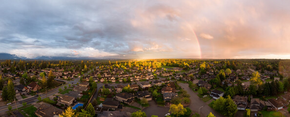 Aerial panoramic view of a suburban neighborhood during a vibrant and colorful sunset. Taken in Greater Vancouver, British Columbia, Canada.