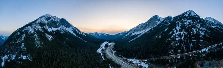 Aerial Panoramic View of a scenic Highway passing in the Canadian Mountain Landscape during a colorful spring sunset. Taken near Hope and Merritt, British Columbia, Canada.