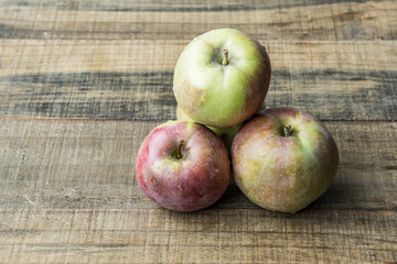 group of fresh apples on a wooden tabletop top view