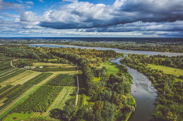 Fields and Vistula river under moody cloudy sky