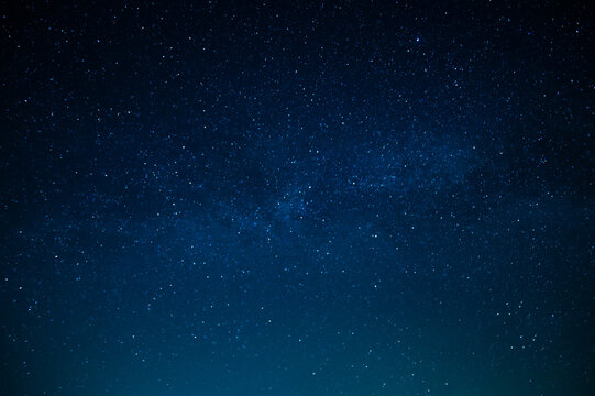 Beautiful night sky. Twinkling stars. Light clouds. Silence and eternity. Galaxy. Deep blue tones. Texture. Background. Wallpaper. There is a place for your inscription.