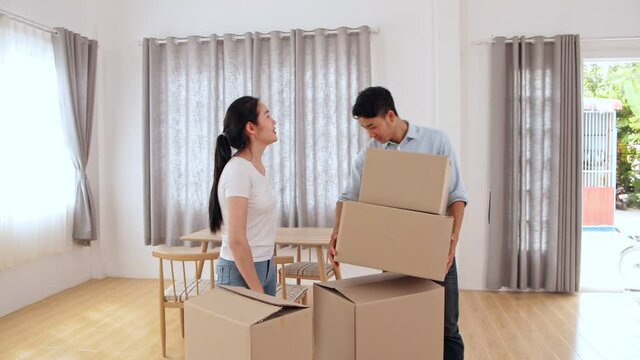 Asian Couple In New House At Moving Day
