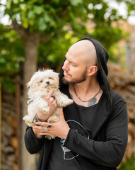 modelo masculino sujetando un cachorro de bichon maltes en las brazos