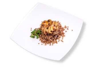 buckwheat with fried mushrooms and herbs on a white plate and white plate
