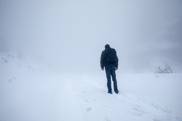 man walks in snowy field