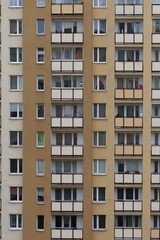 Urban stone jungle. Multiple windows on a large building in the city. Fragment of the facade of high-rise residential buildings. 