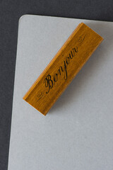 fancy rubber stamp with the word bonjour or hello on grey paper © eugen