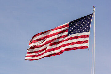 The American flag Flies high in a clear blue sky