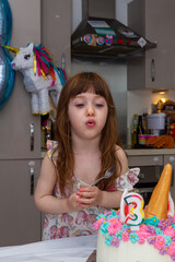 Baby Girl Blowing Candles Of A Birthday Cake